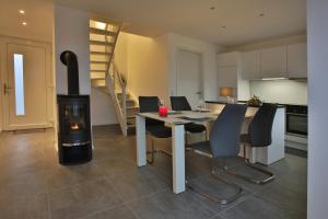 a kitchen and dining room with a wood stove at Exklusives FERIENHAUS im Yachthafen Peenemünde - mit Seeblick in Peenemünde
