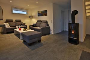 ペーネミュンデにあるExklusives FERIENHAUS im Yachthafen Peenemünde - mit Seeblickのソファと暖炉のあるリビングルーム