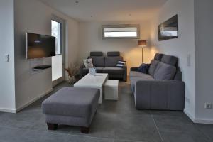 ein Wohnzimmer mit 2 Sofas und einem TV in der Unterkunft Exklusives FERIENHAUS im Yachthafen Peenemünde - mit Seeblick in Peenemünde