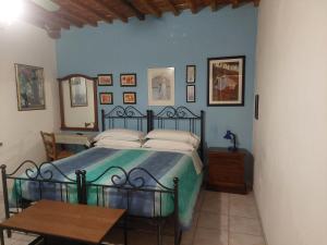 a bedroom with a bed and a table and pictures on the wall at La Convenienza in Cascina