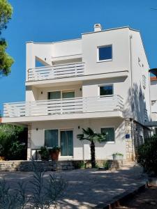 a white house with a tree in front of it at Villa Vista Rovinj - NEW 2024 ! in Rovinj