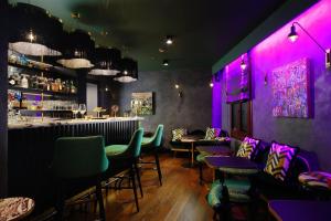 a bar with purple lighting and green chairs at Aqua Palace in Venice