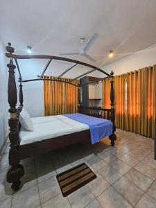 Cette chambre comprend un lit à baldaquin. dans l'établissement Rosanuka Beach Villa, à Wayikkal