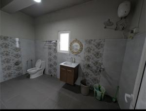 a bathroom with a toilet and a sink at RT Mutbu&Tukthuan in Āīzawl