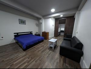 - une chambre avec un lit et un canapé dans l'établissement RT Mutbu&Tukthuan, à Aizawl