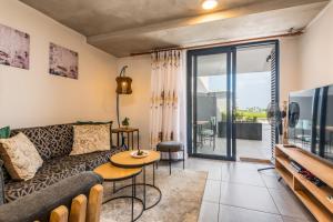 ein Wohnzimmer mit Sofa und Fernseher in der Unterkunft Coral Point Sibaya Luxury Apartment in Sibaya