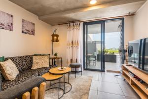 a living room with a couch and a tv at Coral Point Sibaya Luxury Apartment in Sibaya