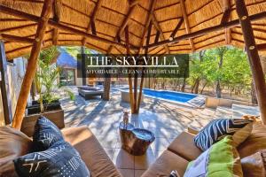 a living room with couches and a swimming pool at African Sky Villas in Marloth Park