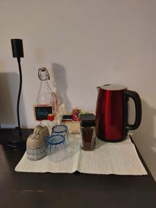 una mesa con una cafetera roja y una lámpara en VentoVerde B&B, en Albenga