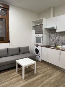 ein Wohnzimmer mit einem Sofa und einem Tisch in der Unterkunft PRADALONGO in Madrid