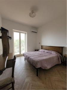 a bedroom with a large bed and a window at Luna D'Agerola in Agerola
