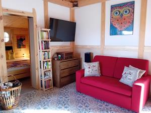 a living room with a red couch and a tv at Domek Sówka na Kociewiu 