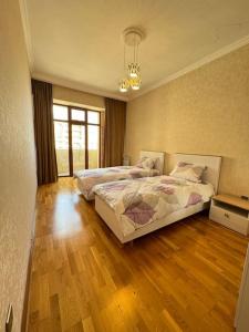 una camera con 2 letti e un pavimento in legno di cozy 2 bd apt mins from downtown a Baku
