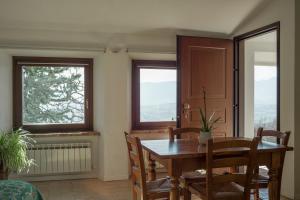 comedor con mesa, sillas y 2 ventanas en Agriturismo Castelvecchio, Case Vacanza a Fabriano, en Fabriano