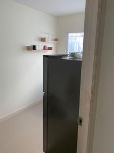 a black refrigerator in a kitchen with a sink at Superb studio Apartment in Ban Na Khua