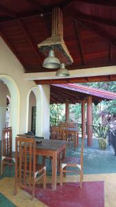 a wooden table and chairs in a house at Rohana Holiday Resort yala in Tissamaharama