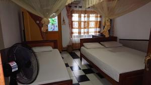 a room with two beds and a fan in it at Rohana Holiday Resort yala in Tissamaharama
