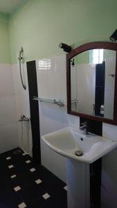 a bathroom with a sink and a mirror at Rohana Holiday Resort yala in Tissamaharama