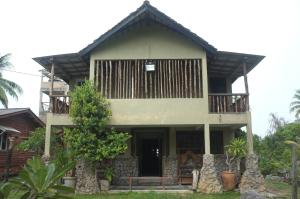 a house with a balcony on top of it at Sepat Village House by the Beach in Kuantan