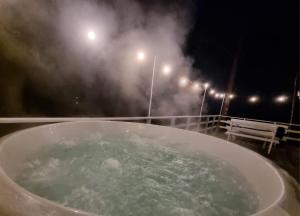 a bath tub filled with water at night with lights at Sosnowy Azyl in Wąglikowice