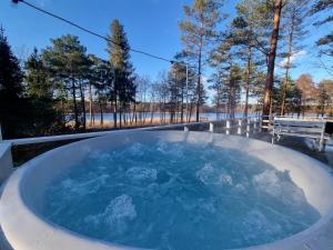 a jacuzzi tub filled with blue water with trees at Sosnowy Azyl in Wąglikowice