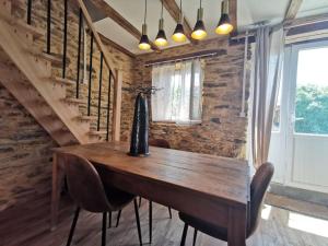 a dining room with a wooden table and chairs at La grange de Pierrot in Saint-Bazile +24 photos