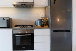 a kitchen with a stove and a refrigerator at Coral Point Sibaya Luxury Apartment in Sibaya