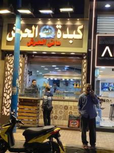 شقة مفروشة 5 سراير في كامب شيزار : رجل واقف امام مطعم وجبات سريعة