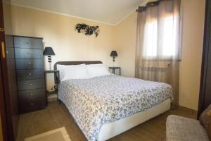 a bedroom with a bed and a dresser and a window at Villa Gusmano in Piedimonte Etneo +22 photos