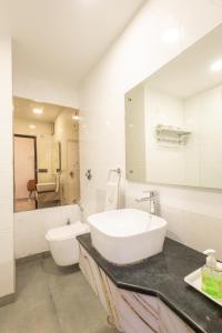a white bathroom with a sink and a toilet at Hotel Cosmo Karol Bagh in New Delhi