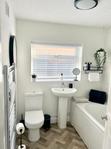 a bathroom with a sink and a toilet and a bath tub at 2 bedroomed house close to Cleethorpes seafront in Cleethorpes