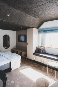 1 dormitorio con 1 cama, ventana y TV en Nymindegab Kro, en Nørre Nebel