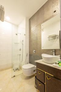 a bathroom with a toilet and a sink and a shower at Hotel Cosmo Karol Bagh in New Delhi