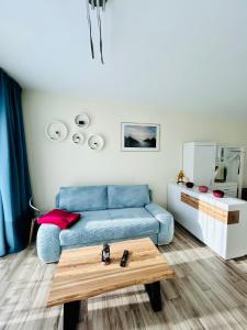 uma sala de estar com um sofá azul e uma mesa em Fewo Graal Müritz Sobierajczyk em Gelbensande