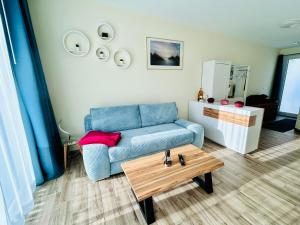 ein Wohnzimmer mit einem blauen Sofa und einem Couchtisch in der Unterkunft Fewo Graal Müritz Sobierajczyk in Gelbensande