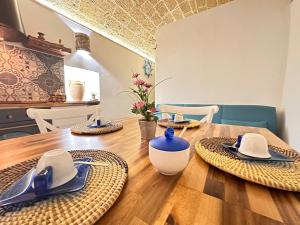 una mesa de madera con platos y utensilios. en Agnese Experience Suite en Gallipoli