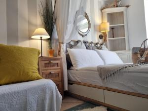 - une chambre avec un lit et un miroir mural dans l'établissement Le Petit Phare, à Trieste