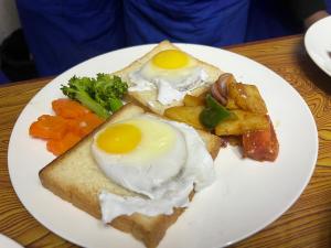 une assiette de denrées alimentaires contenant des œufs et des légumes sur une table dans l'établissement Hotel Eco View Point Pvt.Ltd, à Tāplejung