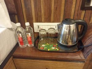 a tea kettle on a tray next to bottles of water at KS PAYING GUEST HOUSE in Varanasi