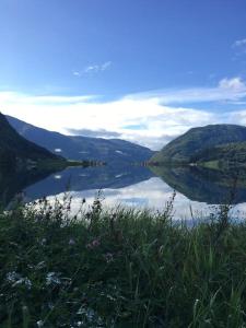 uma vista para um lago com montanhas ao fundo em Cozy Retreat and danish design in Nature's Splendor, Sogn, Norway, Jacuzzi-option available em Sogndal