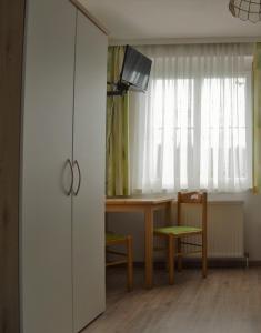 ein Wohnzimmer mit einem Tisch und einem weißen Schrank in der Unterkunft Frühstückspension Sterr in Strebersdorf