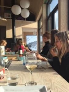 un grupo de personas sentadas en una mesa con una copa de vino en Cozy Retreat and danish design in Nature's Splendor, Sogn, Norway, Jacuzzi-option available, en Sogndal