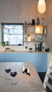 dos vasos de vino sentados en una mesa en una cocina en Cozy Retreat and danish design in Nature's Splendor, Sogn, Norway, Jacuzzi-option available, en Sogndal