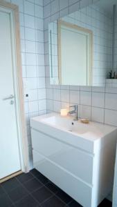 Baño blanco con lavabo y espejo en Cozy Retreat and danish design in Nature's Splendor, Sogn, Norway, Jacuzzi-option available, en Sogndal