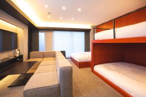 sypialnia z 2 łóżkami piętrowymi i telewizorem w obiekcie GOLD STAY Nagoya Osu w mieście Nagoja