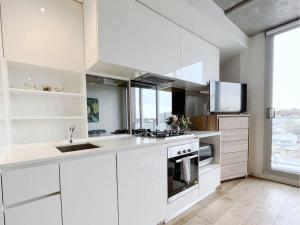 a white kitchen with a sink and a stove at Beautiful 1B1B Prahran apartment in Melbourne +8 photos