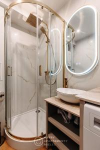 een badkamer met een douche en een wastafel bij Happy Gold - Happy Apartamenty Mielec in Mielec
