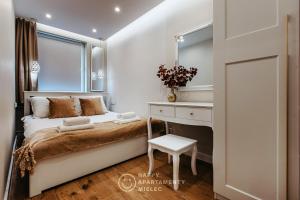 a bedroom with a bed and a desk and a window at Happy Gold - Apartamenty Happy Mielec in Mielec