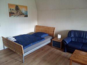 a bedroom with a bed and a blue couch at Zum Bothmerschen Krug in Schwarmstedt