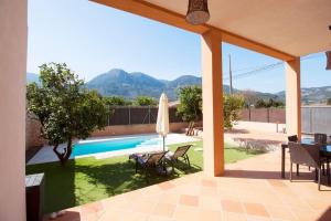 a patio with a pool and a table and a umbrella at Ground floor with garden, swimming pool and private parking in Sóller